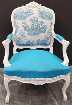 a blue and white chair sitting on top of a wooden floor next to a wall