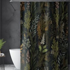 a bathroom with a shower curtain that has plants and leaves on it in front of a gray wall