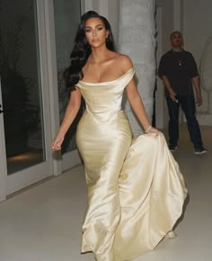 kim kardash in an off - the - shoulder dress walking down a hallway