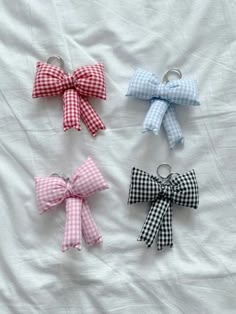 four small bows are tied together on a white sheet with black and white gingham