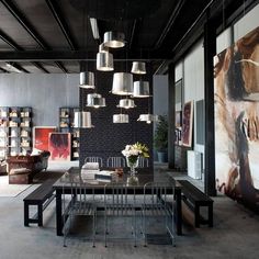 an industrial style dining room with art on the walls and artwork hanging from the ceiling