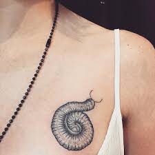 a woman's chest with a snail tattoo on it