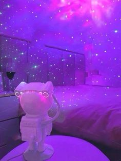 a room with purple lights and a cat figure on the table in front of it