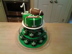 a three tiered cake decorated with footballs and the number 50 on each layer