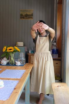 a woman standing in front of a table covering her eyes