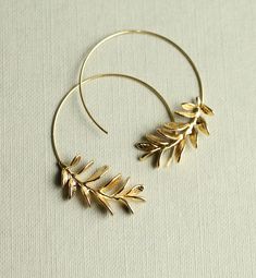 These rosemary leaf hoop earrings are made from solid brass with some amazing detail on the leaves.  They feature a detailed botanical sprig of leaves, in a rich golden brass tone.   The hoop earrings are available in two size option:  ★ SMALLER ★ 3.5cm (an inch and a half) Diameter  ★  LARGER  ★ 5cm (two inches) Diameter  This piece of jewellery comes packaged in a nice recycled gift box with a handmade tag, all ready to give or keep. 🖤 FASTER SHIPPING 🖤 Need this fast? We offer a Faster Shipping option here: https://www.etsy.com/uk/listing/100107311/faster-shipping-priority-post-upgrade 🖤 GIFT MESSAGE & WRAP SERVICE! 🖤 https://www.etsy.com/uk/listing/750160511/gift-wrap-wrapping-personalised-card?ref=listings_manager_table Handmade Gold Hoop Earrings Nature-inspired, Handmade Gold Hoop Earrings With Nature-inspired Style, Handmade Gold Nature-inspired Hoop Earrings, Gold Handmade Nature-inspired Hoop Earrings, Brass Hoop Wrap Earrings As Gift, Nature-inspired Gold Hoop Earrings For Pierced Ears, Gold Leaf-shaped Hoop Earrings For Gift, Gold Leaf Hoop Earrings, Woodland Earrings