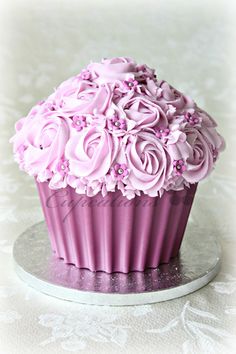 a cupcake with pink frosting and flowers on top