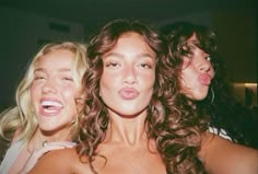 three women are posing for the camera with their mouths open