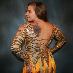 will fit size 5/6-9/10, stretchy Crafted from lustrous gold-hued hologram tiger print metallic lycra, this Latin-rhythm dress features lattice strapping on the long sleeves, bodice, & low cut back. Several skirt panels combine with vertical chainette fringe in gold & yellow tones to capture all your dynamic Latin-rhythm moves. As you show off your passionate motion & spins, you'll look and feel fiercely fabulous! Many variations can be custom made especially for you, in other colors, fabrics, & Gold Fitted Dance Dress, Gold Fitted Dress For Dance, Rhythm Dress, Gold Tiger, Latin Dress, Dress With Long Sleeves, Yellow Tones, Tiger Print, Gold Yellow