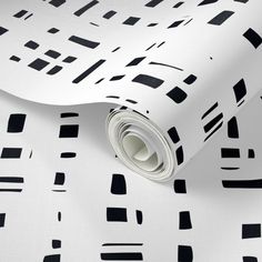 black and white wallpaper with geometric shapes on the paper, which is rolled up