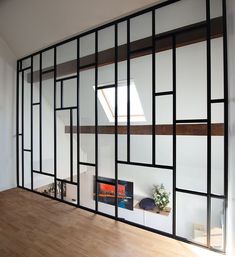 an empty room with wood flooring and glass partitions on the wall to allow light in