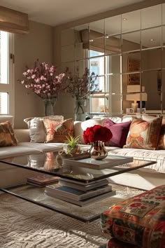 a living room filled with lots of furniture and flowers on top of a coffee table