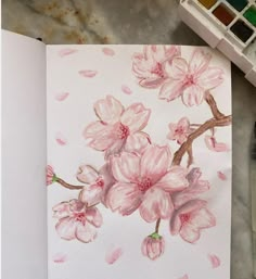 a painting with pink flowers on it next to watercolors and paintbrushes