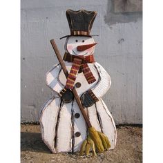 a snowman made out of wood with a broom and hat on it's head