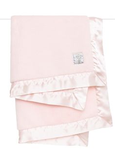 the pink blanket is folded up and ready to be used as a baby bedding