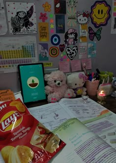 there is a bag of chips on the desk next to two stuffed animals and a notepad