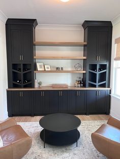 a living room filled with lots of furniture next to a wall mounted wine rack and cabinets