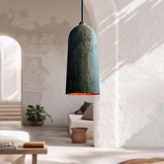 a light that is hanging from a ceiling in a room with white walls and furniture