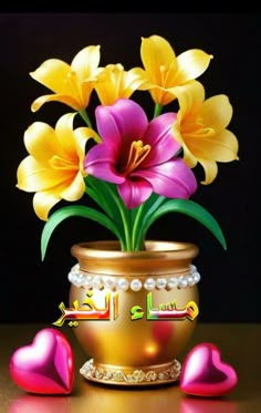 a vase filled with yellow and pink flowers on top of a table next to hearts