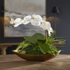 white orchids and ferns in a bowl on a table