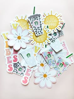 various stickers and tags on a pink surface with flowers in the middle, including sunflowers