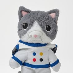 a gray and white cat stuffed animal wearing a space suit with polka dots on it's chest