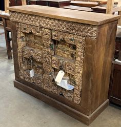 an old wooden cabinet with many doors and drawers on display in a store or showroom