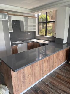 a kitchen with an island in the middle of it and wood flooring on the other side