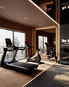 an exercise room with treadmills and windows