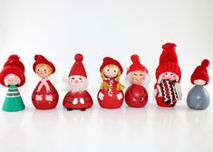 a group of red and green gnomes sitting next to each other on a white surface