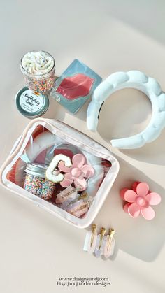 the contents of a crafting kit are arranged on a white surface with pink flowers