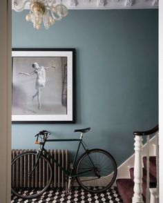 a bicycle is parked in front of a painting on the wall next to a radiator