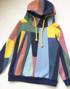 a multicolored hoodie is hanging on the wall