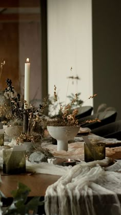 the table is set with candles and flowers in vases on top of paper towels