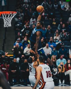 a basketball player jumping up to dunk the ball in front of two other players