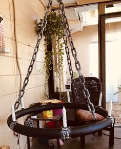 a chair that is sitting in a room with chains hanging from it's sides