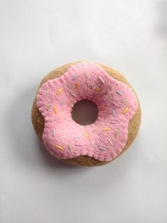 a donut with pink frosting and sprinkles on it's side