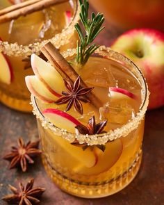 two glasses filled with apple cider next to cinnamon sticks and star anisette