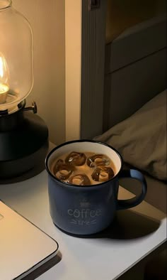 a cup of coffee sitting on top of a table next to a laptop