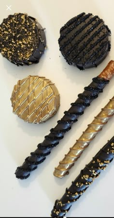 four different types of desserts on a white surface with gold and black icing