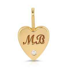 a gold heart charm with the letter m and b on it's front side