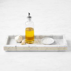 a bottle of oil sitting on top of a marble tray