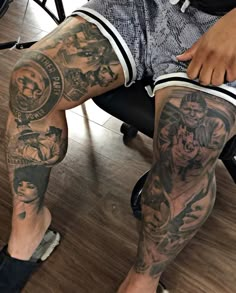 a man with tattoos on his legs sitting in a chair