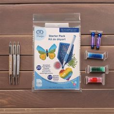 the starter pack includes pens, markers, and other crafting supplies on a wooden surface