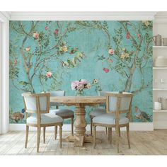 a dining room table with four chairs and a wallpapered mural in the background