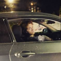 a woman sitting in the driver's seat of a car