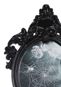 a black frame with a spider web and roses on the front is shown in white