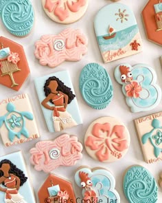 decorated cookies are arranged on a white surface with blue and orange accents, including an image of a woman