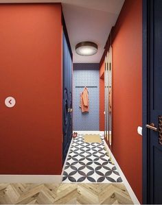 an orange and blue hallway with a coat rack on the wall next to a tiled floor