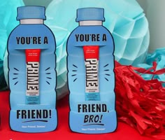 two bottled water bottles with the words you're a friend on them sitting next to red and blue streamers